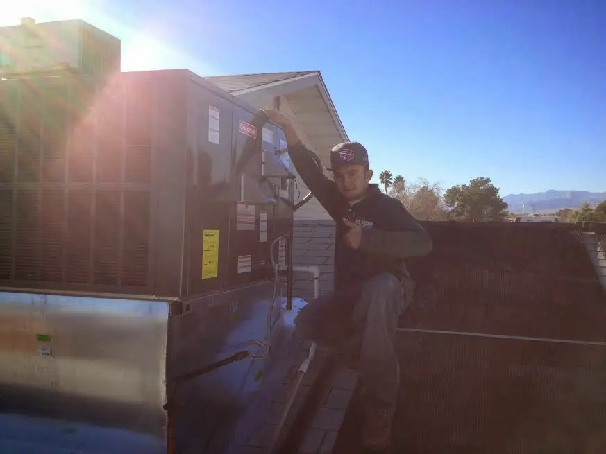 HVAC technician performing HVAC Inspection on a rooftop unit in Somerton